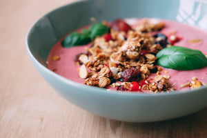 Pink smoothie bowl with red berries