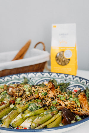 green asparagus on a plate with crunchy savoury granola and creamy puree