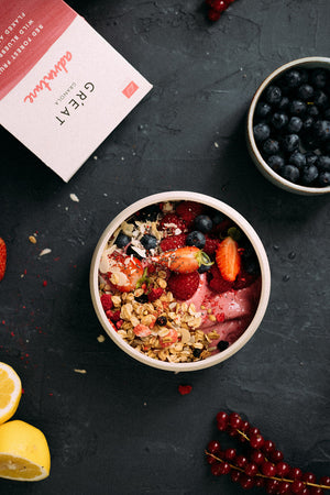 red berries smoothie bowl with peanut butter and crunchy granola